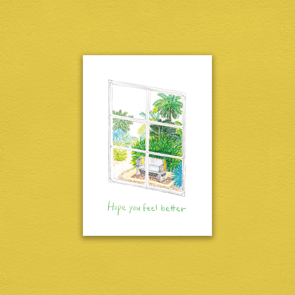 color pencil drawing of a green landscape is seen through a window. Words that wishes get well soon is written below the image as a greeting on the greeting card